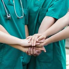 Teamwork: Krankenschwestern und Ärzte legen Hände aufeinander