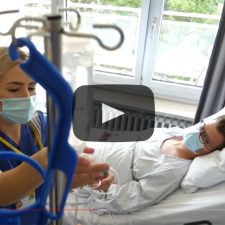 Vorschaubild Pflegefilme - Pflegerin versorgt im Bett liegenden Patienten