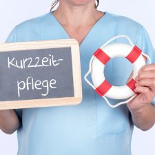 Pflegekraft mit einem Rettungsring und einer Tafel auf der Kurzz