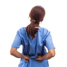 Eine Krankenschwester, die sich schmerzvoll den Rücken hält