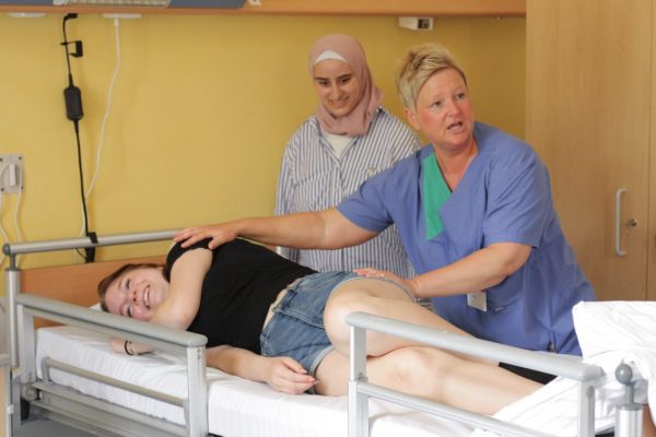 Pflegekraft des SHG Klinikum Merzig zeigt SchülerInnen wie man einen Patienten stabilisiert