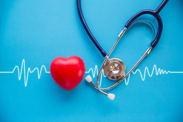 Rotes Herz und Stethoskop vor blauem Hintergrund