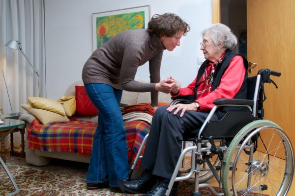Seniorin im Rollstuhl mit pflegender Angehörige