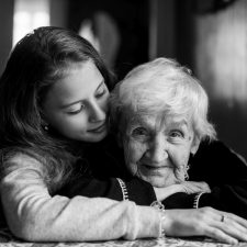Jugendliche umarmt Seniorin
