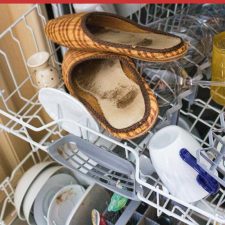 Pantoffeln liegen beim schmutzigen Geschirr in der Spülmaschine