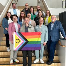 Gruppenbild der Referenten und Kooperationspartner die eine Flagge hochhalten