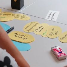 Gelbe und blaue Klebezettel, die beschriftet werden und auf einem Tisch liegen